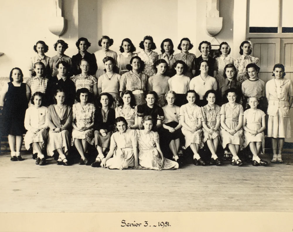 Girls of Senior 3 gather indoors in tiered rows for a class photograph, captioned "Senior 3 – 1951."