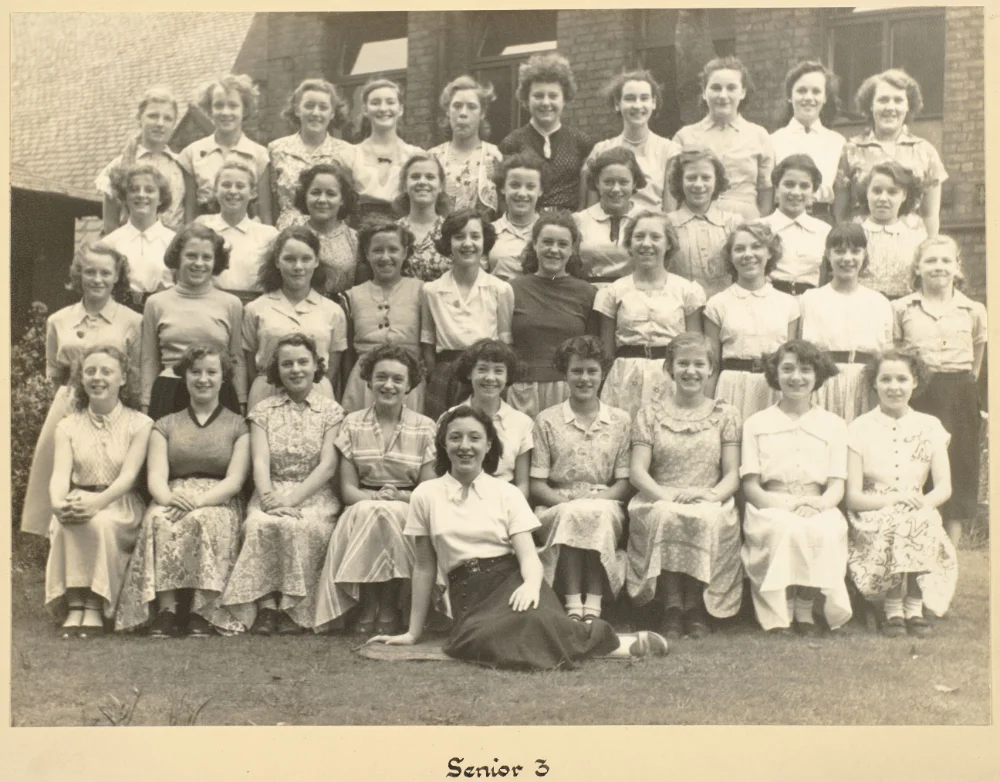 Older pupils of Senior 3 gather on the grass in tiered rows for a class photograph, captioned "Senior 3."