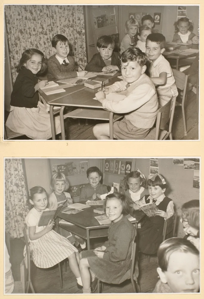 Two photographs of infant pupils at classroom tables writing and reading, with wall posters and a curtained window visible.