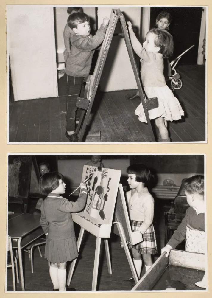 Two photographs of infant pupils drawing and painting at classroom easels, with a doll's pram visible in the background of the upper scene.